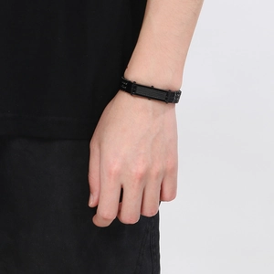 Dettaglio del bracciale in acciaio inossidabile nero opaco al polso per uno stile punk hip hop