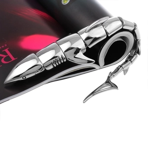 Close-up of a silver punk scorpion-style jointed armor ring on colorful magazine background