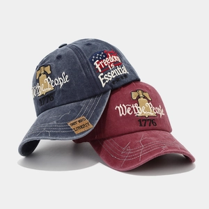 Close-up of vintage washed baseball caps with Freedom is Essential embroidery and flag patch