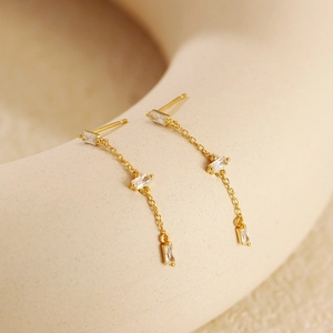 Detail of s925 silver gold tassel chain earrings with rectangular white zircon stones