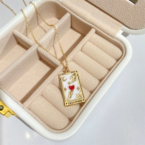 Detailed view of The Lovers tarot card pendant with gold details in white jewelry box