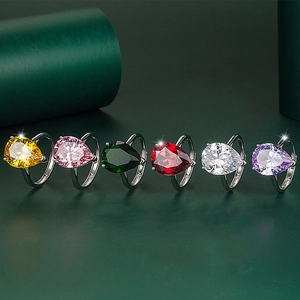 Macro shot of colorful pear cut gemstone rings with silver adjustable bands and claw settings