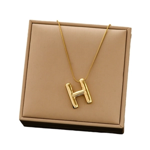Minimalist 3D balloon style letter H pendant on a dainty gold snake chain necklace