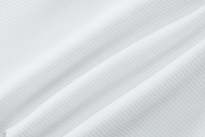 Close-up of white ribbed knit fabric texture showing vertical stripes and soft drape
