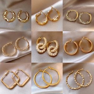 Collection of nine gold hoop earrings featuring geometric shapes and cubic zirconia accents