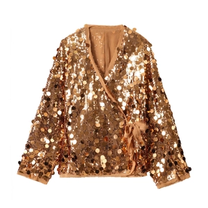 Detail of golden sequin wrap jacket featuring large round scales and waist tie closure