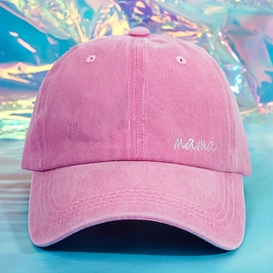 Close-up of MAMA white embroidery on vintage pink washed cotton baseball cap with stitching
