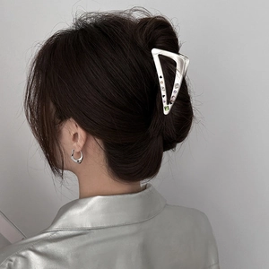 Detail of a large Y2K silver hollow triangle metal hair claw with colorful rhinestones