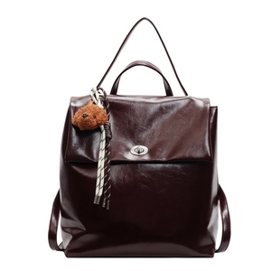 Vintage dark brown glossy leather backpack with silver turn-lock and plush puppy charm