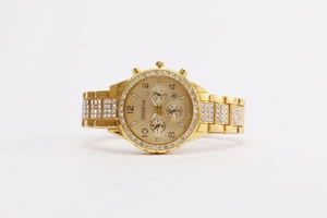 Close-up of Geneva women's gold quartz watch with rhinestone bezel and calendar display