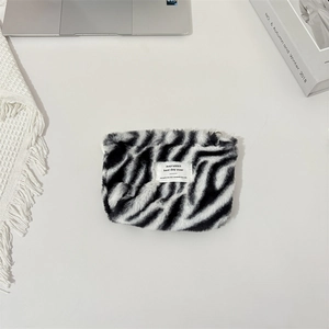 Detail of plush zebra print cosmetic bag with soft texture and stylish zipper closure