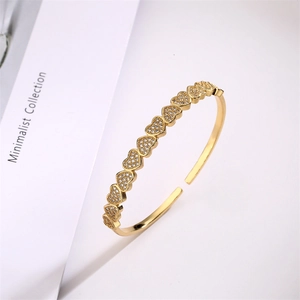 Close-up of gold star and heart open cuff bracelet with paved cubic zirconia details