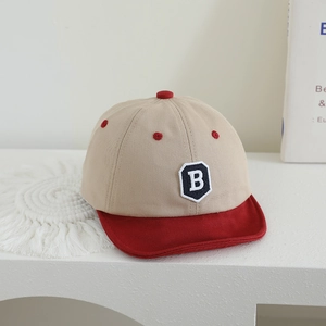 Close-up of baby baseball cap with letter B patch and contrast soft brim detail