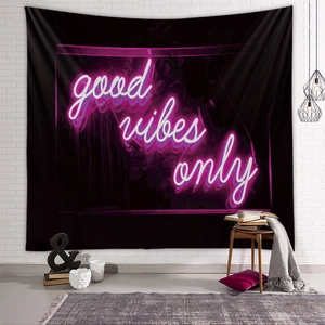 Detail of neon-style Good Vibes Only lettering on a black fabric wall tapestry backdrop