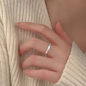 Detailed close-up of a silver minimalist ring with spiral ribbed texture on model's hand