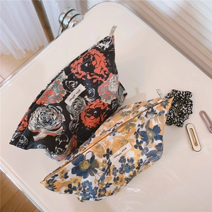 Detail view of floral cotton makeup bags with simple wish label and metal zipper