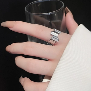 Detail of silver geometric ring with white zircon stones on model's finger