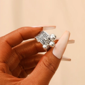 Close-up of vintage silver multi-layer textured ring with three small bell charms