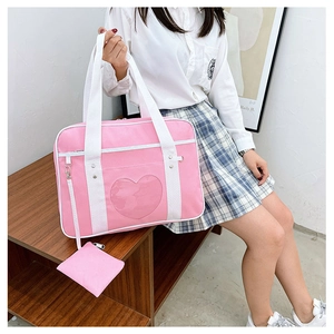Detailed view of pink JK travel bag with heart-shaped window and small coin purse