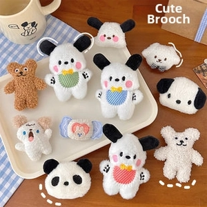Detailed close-up of cute plush animal brooches featuring Pochacco and teddy bear designs