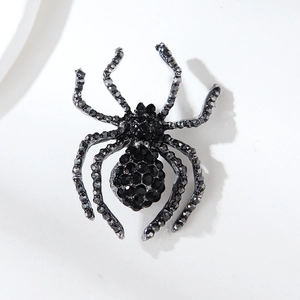 Detailed view of vintage spider brooch with faceted black rhinestones and dark metal frame