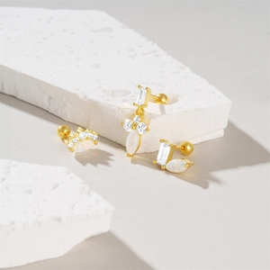 Detail of gold screw-back earring with white opal and sparkling marquise cut cubic zirconia