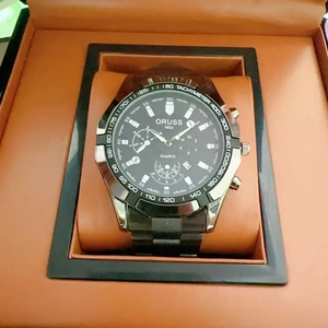 Macro view of men's quartz watch with black steel strap and tachymeter scale in gift box
