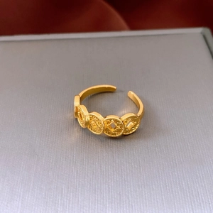 Macro view of gold 18K plated bow-knot ring with retro coin pattern detail