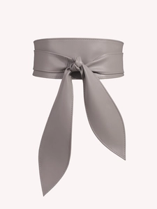 Macro shot of the taupe faux leather wide waist belt with a stylish bow tie knot detail