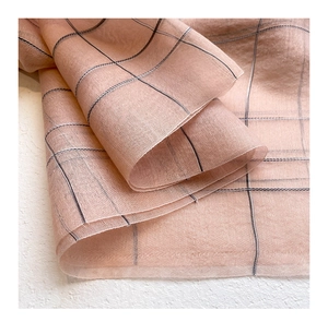 Detailed macro view of light pink silk wool fabric with fine black grid texture