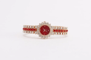 Details einer roségoldenen Quarzuhr mit rotem Zifferblatt und Kristall-Armbanduhr