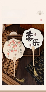 Detail of Chinese style silk fans with wood handles and golden tassels in zen setting