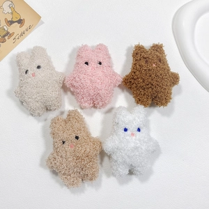 Detail showing five assorted colors of fluffy plush rabbit brooches for accessories
