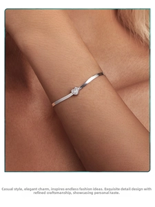 Detailed close-up of a silver heart-shaped zircon bracelet on a woman's wrist