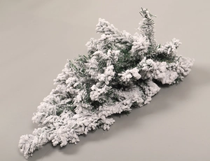 Detailed view of artificial frosted pine branch with thick white flocking and snow effect