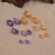 Macro detail of raw stone charms in purple and orange with golden loops for DIY jewelry