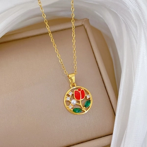 Macro shot of gold tulip pendant with red flower and pearl in a beige jewelry box
