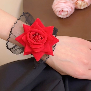 Détail d'une rose rouge en velours avec dentelle noire sur un bracelet de poignet chic