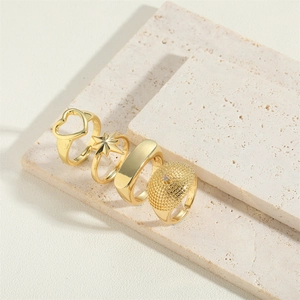 Set of four gold heart and star vintage rings on travertine stone display