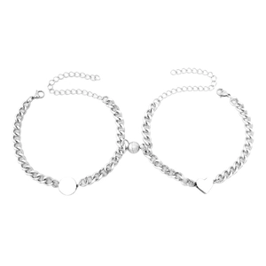 Detail of silver Cuban link couple bracelets with magnetic heart and round pendants