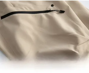 Detail of waterproof taped zipper and adjustable drawstring on tech cargo pants