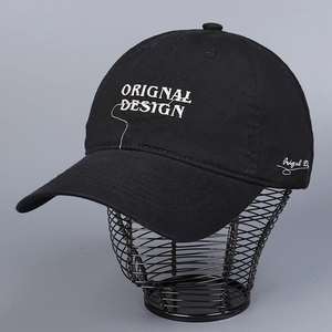 Close-up of white letter embroidery and stitching on a black cotton baseball cap