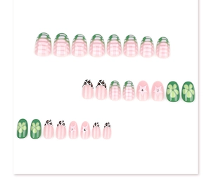 Detail of short round press-on nails in green leopard and floral summer patterns