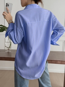 Detail of blue and white striped long sleeve shirt showing the relaxed back yoke design