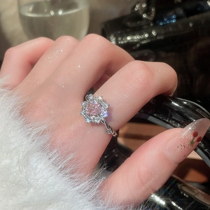 Detail of flower shaped ring featuring pink square zircon and silver twisted band