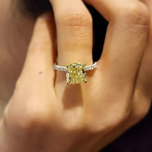 Luxurious gold ring with square yellow gemstone and diamond accents on hand