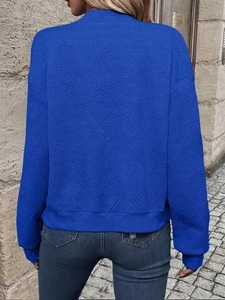 Detail of royal blue textured knit jacket with geometric jacquard and ribbed cuffs