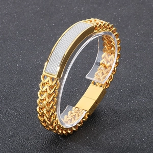 Detail of hip hop men's gold bracelet with magnetic clasp and woven textured steel plate