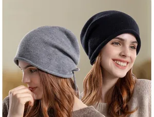 Close-up of knitted slouchy beanies in grey and black with soft winter texture