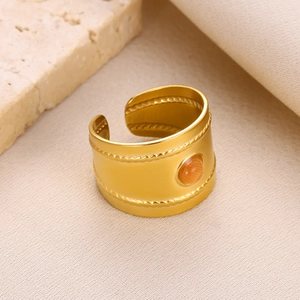 Detailed shot of gold-plated wide open ring with dual woven texture and orange gemstone
